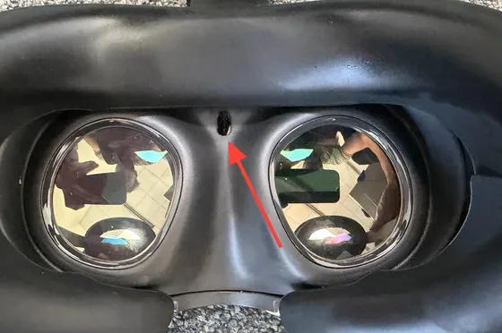 Blick in die Meta Quest 3 von innen. Ein roter Pfeil zeigt auf den kleinen Näherungssensor über dem Nasenausschnitt zwischen den beiden Linsen.